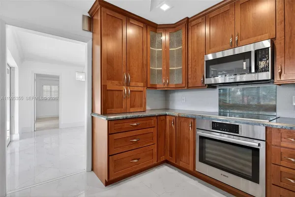 a kitchen with stainless steel appliances granite countertop a refrigerator stove and microwave