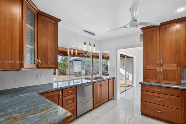 a kitchen with stainless steel appliances granite countertop a sink and a large window