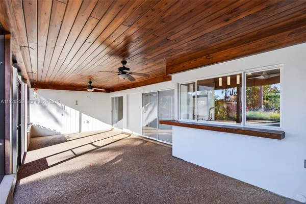 a view of a porch with furniture and floor to ceiling window