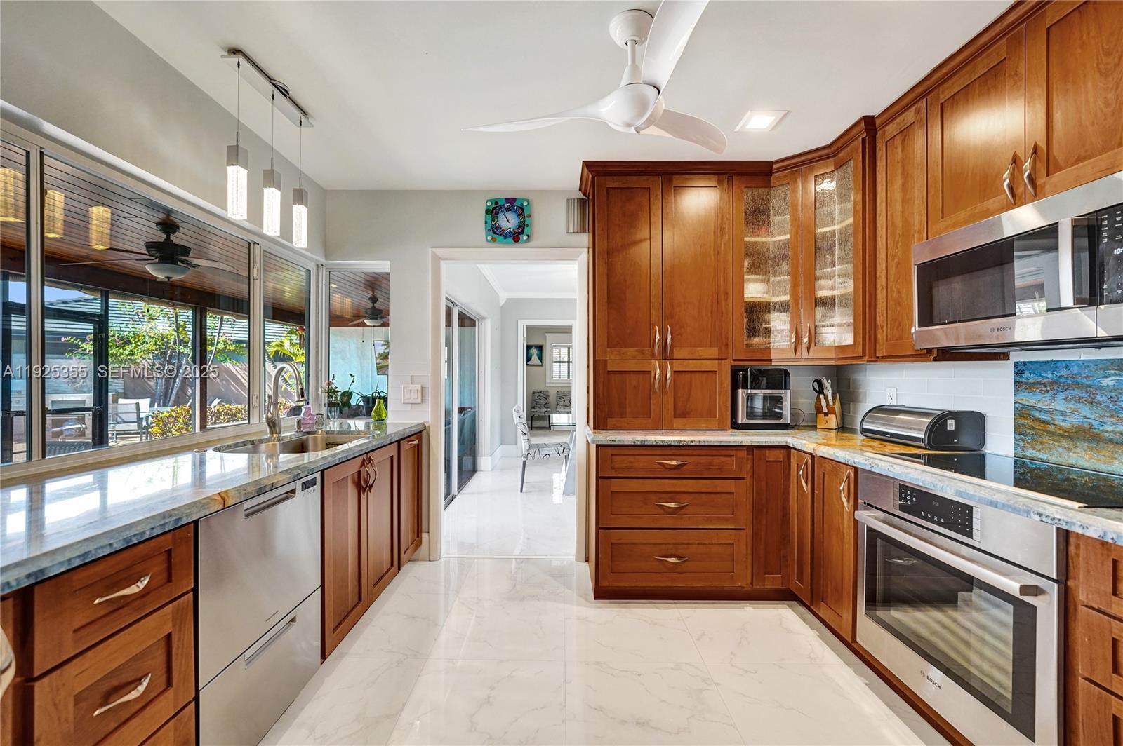 4060 Northeast 26th Avenue Lighthouse Point, FL 33064 - Photo 8 of 34 a large kitchen with stainless steel appliances granite countertop a large stove a refrigerator a sink and dishwasher with a large window