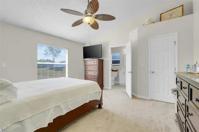 a bedroom with a bed and a flat tv screen on dresser