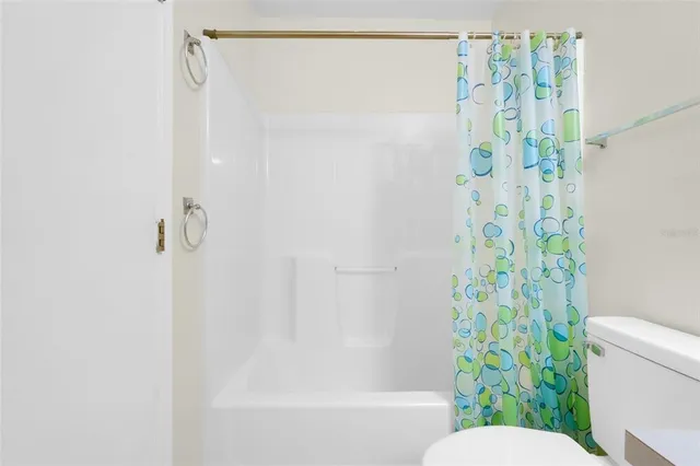 a bathroom with a shower curtain and a toilet