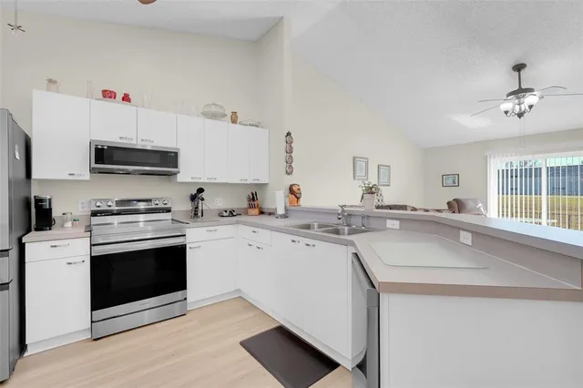 a kitchen with stainless steel appliances a sink stove and cabinets