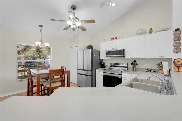 a kitchen with a refrigerator a stove a sink dishwasher with a dining table and chairs