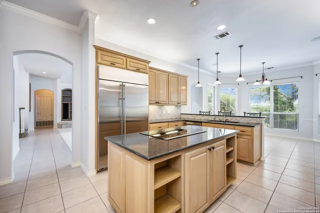 a kitchen with kitchen island granite countertop a stove a sink and a refrigerator
