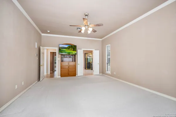 a view of a kitchen with an entryway and a ceiling fan