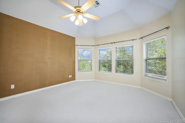 an empty room with windows and fan