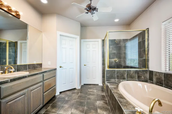 a bathroom with a tub sink and mirror