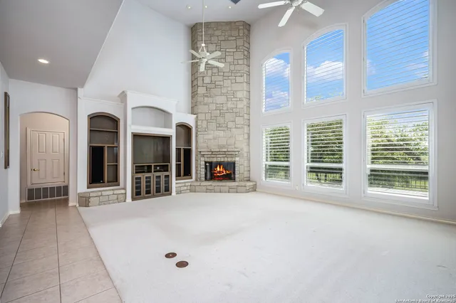 a view of an empty room with a fireplace and a window