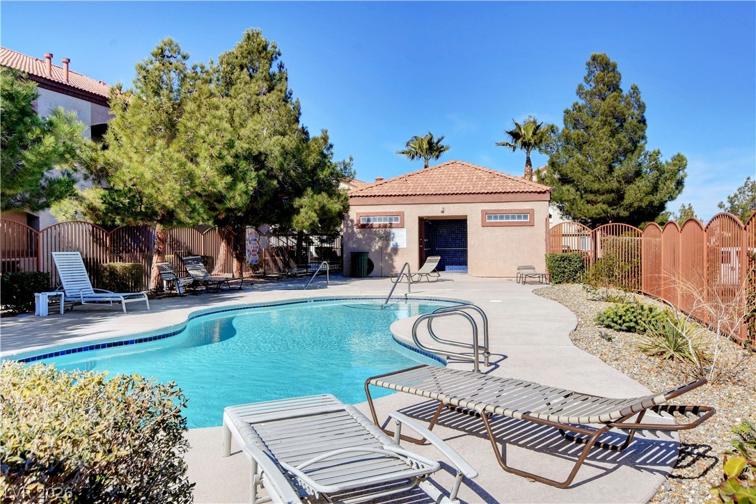 9580 West Reno Avenue, Unit 134 Las Vegas, NV 89148 - Photo 41 of 41 Lush landscaping surrounds a sparkling pool, ideal for leisurely afternoons.