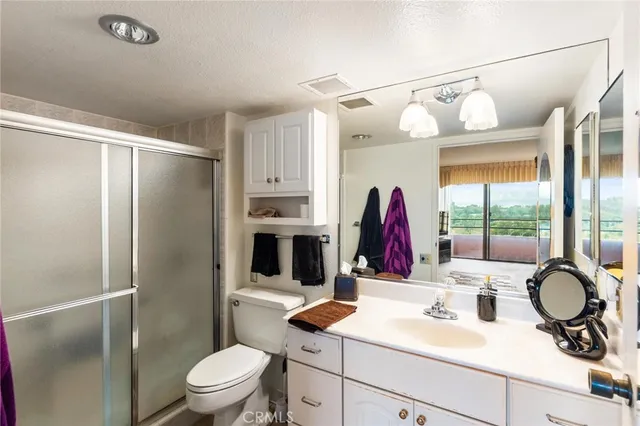 a bathroom with a sink toilet mirror and shower
