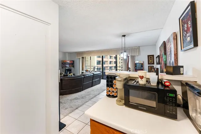 a living room with furniture a flat screen tv and a refrigerator