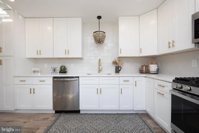 a kitchen with stainless steel appliances granite countertop a sink and white cabinets