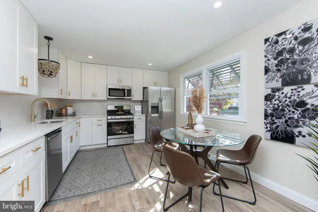 a kitchen with granite countertop a table chairs microwave and cabinets