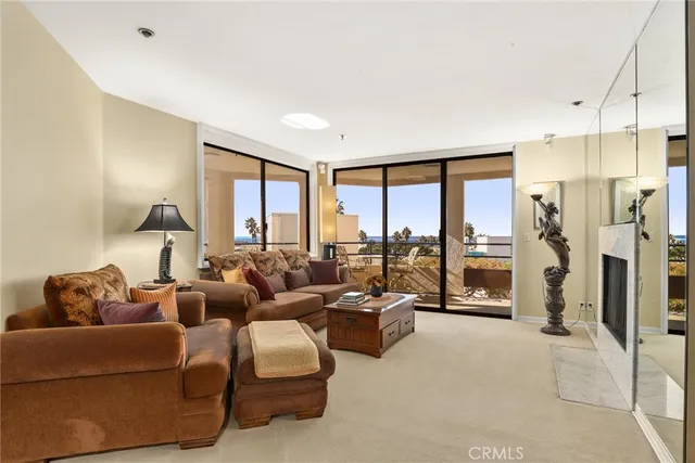 a living room with furniture large windows and a fireplace