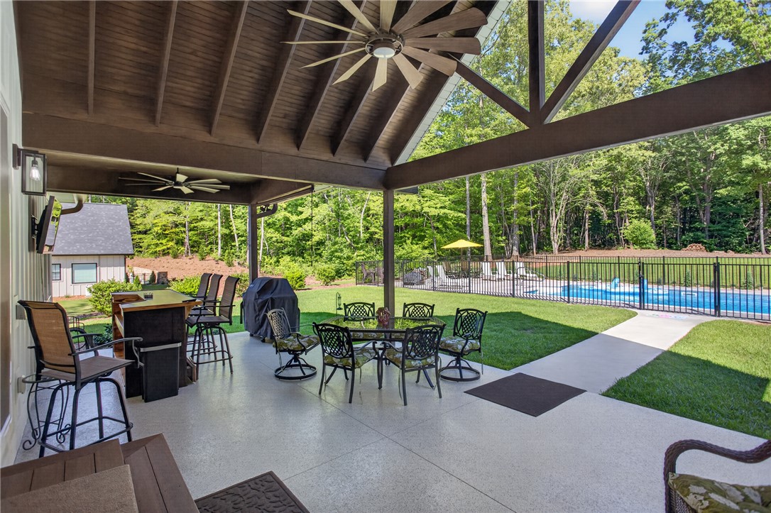 921 Falling Waters Lane Seneca, SC 29672 - Photo 36 of 46 An inviting covered patio with exposed beams offers outdoor living and recreation by the private pool.