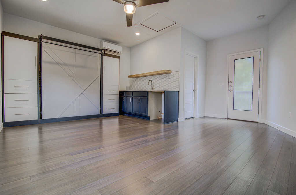 2406 East 16th Street Austin, TX 78702 - Photo 33 of 39 an empty room with wooden floor cabinet and windows