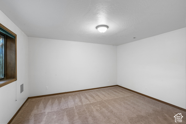 1373 Pheasant Ridge Circle Bountiful, UT 84010 - Photo 38 of 50 Carpeted room with white walls, a single window with wood trim, and a flush-mount ceiling light
