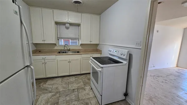 a kitchen with a sink stove and cabinets