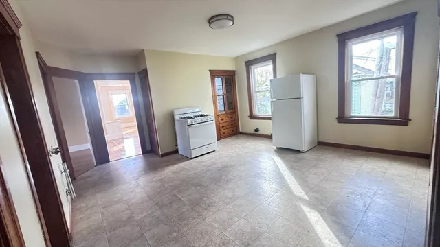 a view of an empty room with a fireplace and a window