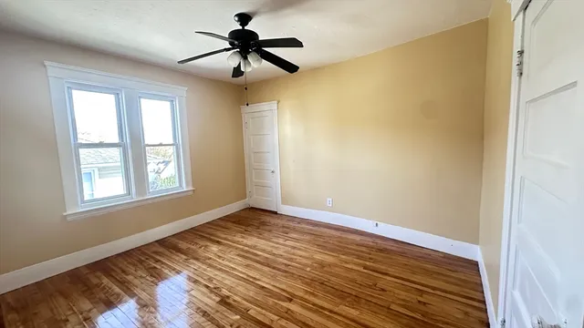 a view of room with hardwood floor and ceiling fan