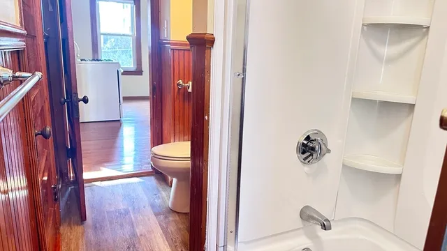 a view of a hallway with wooden floor and windows