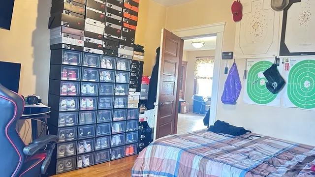 a bedroom with a bed and wooden floor