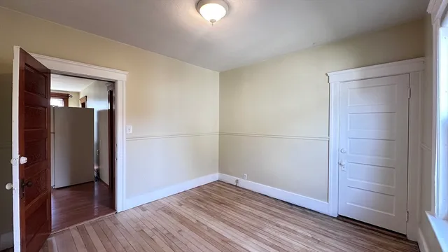 an empty room with wooden floor and closet