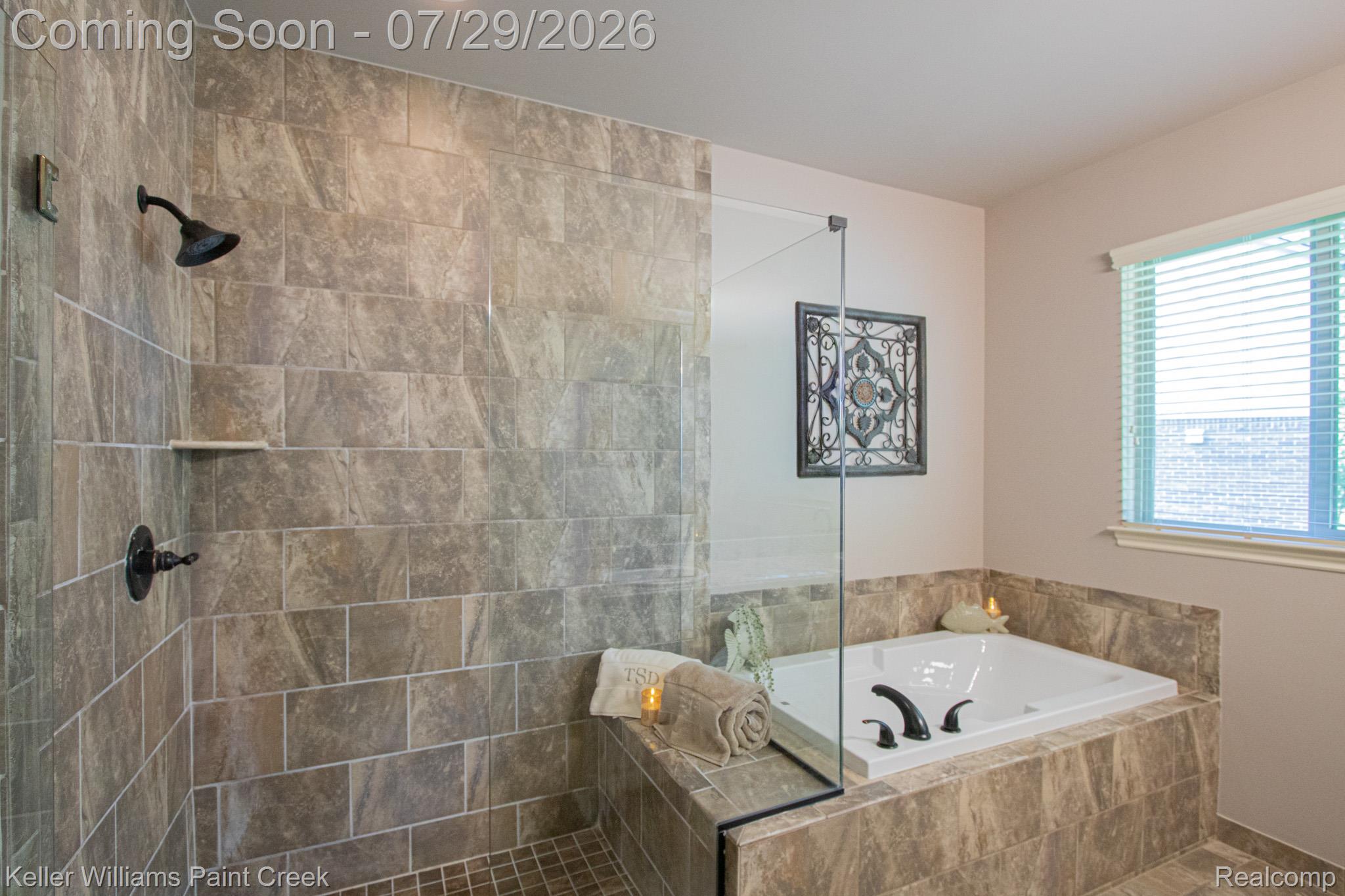 49118 Ridgeview Drive Macomb, MI 48044 - Photo 25 of 57 Tiled shower with dark bronze fixtures and glass enclosure, accompanied by a built-in jetted tub surrounded by coordinating tilework