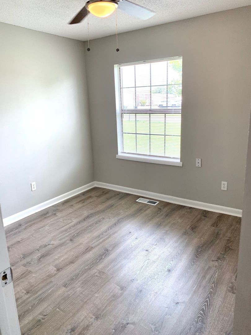 208 State Line Road Clarksville, TN 37042 - Photo 13 of 23 an empty room with wooden floor and windows
