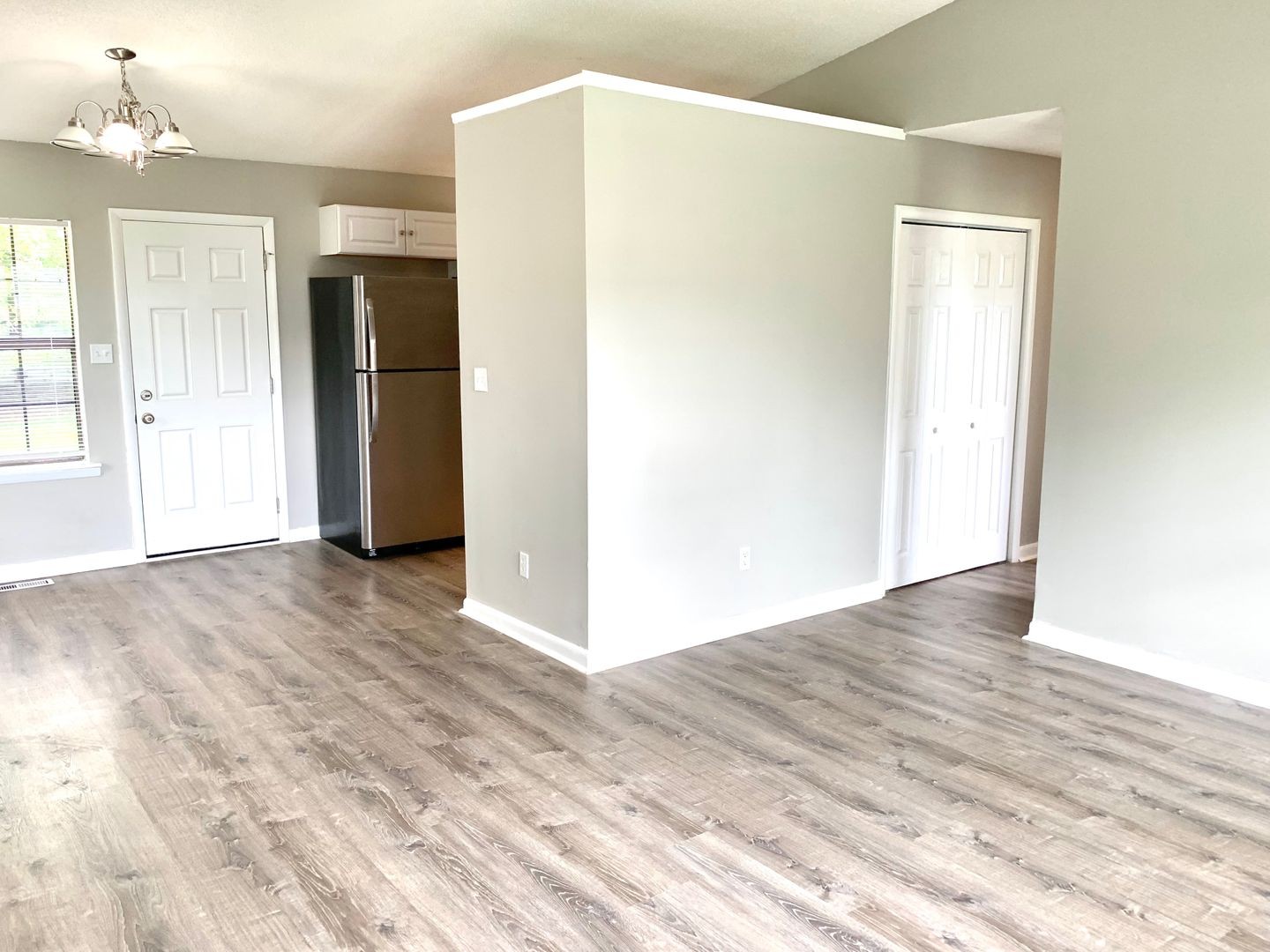 208 State Line Road Clarksville, TN 37042 - Photo 4 of 23 a view of an empty room with wooden floor and a kitchen