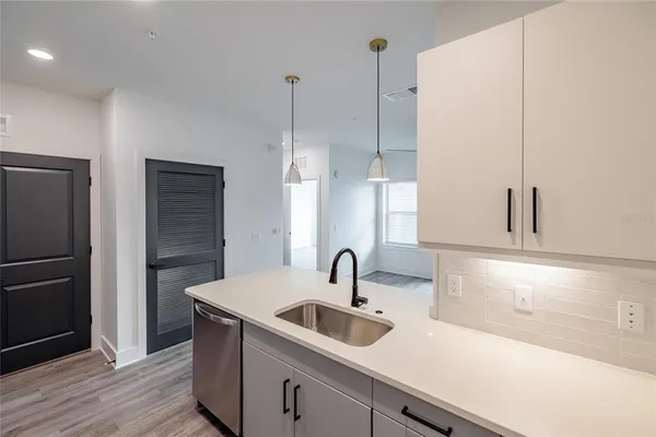 a kitchen with a sink a counter top space stainless steel appliances and cabinets