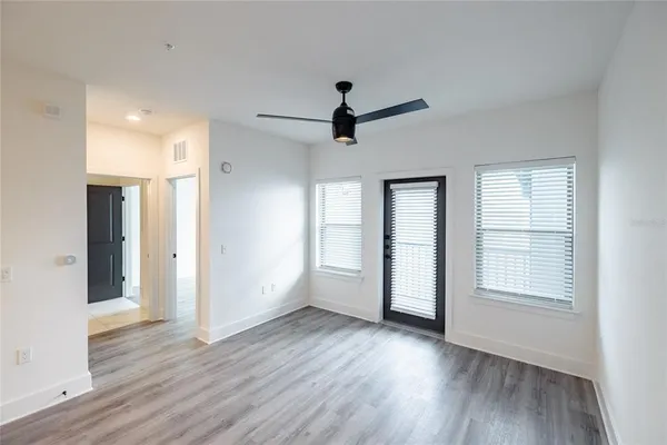 a view of empty room with wooden floor and ceiling fan
