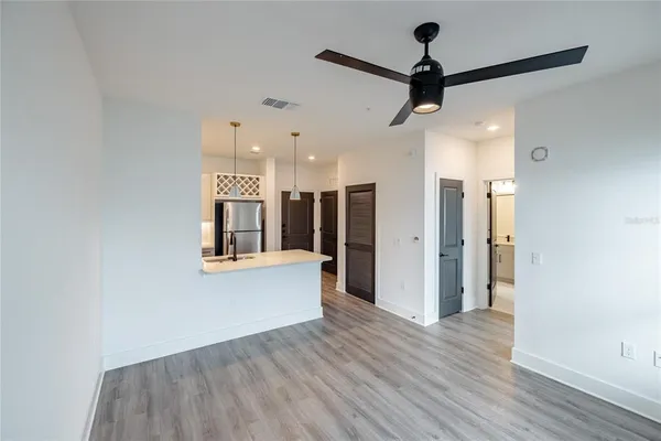 a view of a hallway with wooden floor and a ceiling fan