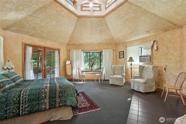 a bedroom with furniture and large windows