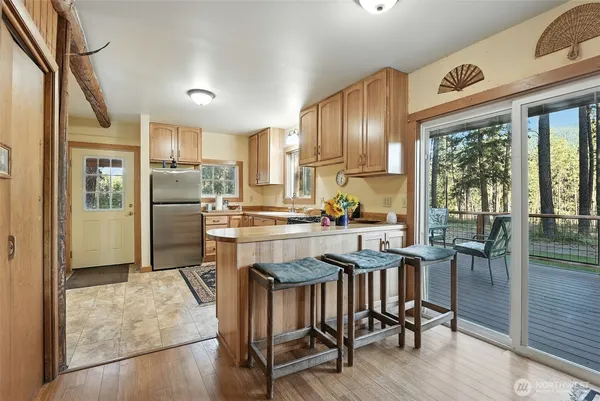 a kitchen with granite countertop a refrigerator a stove a dining table and chairs