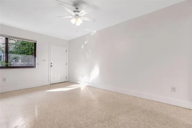 an empty room with a window and a ceiling fan