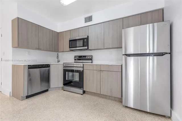 a kitchen with white cabinets and white stainless steel appliances and refrigerator