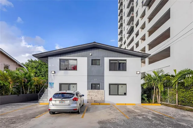 a car parked in front of house with yard