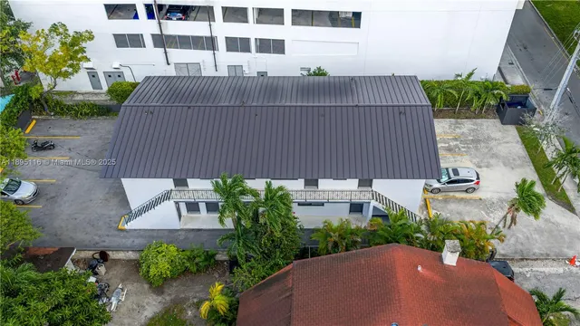 a view of a street with potted plants and brick walls
