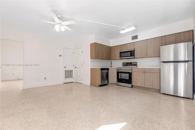a kitchen with stainless steel appliances a refrigerator and a stove top oven