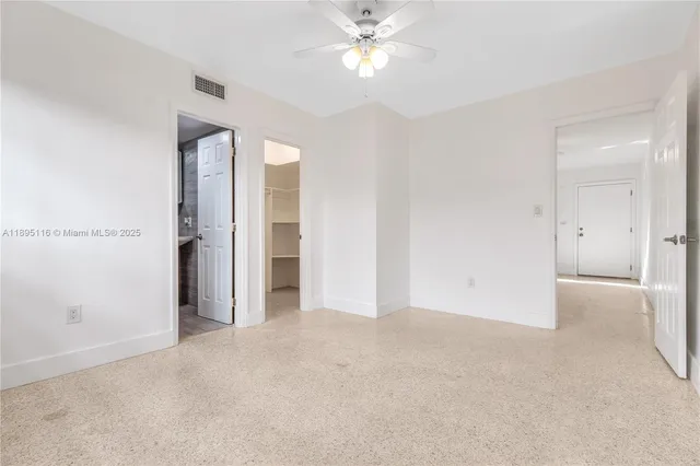 an empty room with closet and a chandelier fan