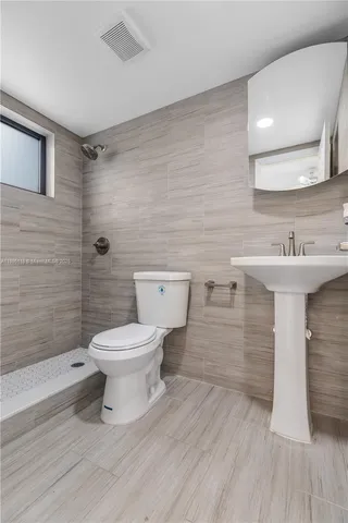 a bathroom with a sink toilet and shower