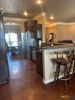 a kitchen with stainless steel appliances a dining table chairs and granite counter tops