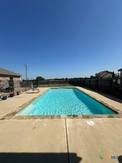 a swimming pool with outdoor seating and yard