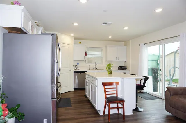 a kitchen with granite countertop a refrigerator and a stove top oven