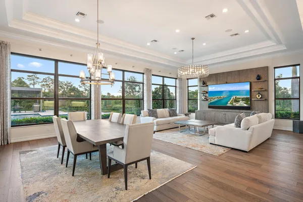 a living room with furniture a chandelier and a large window