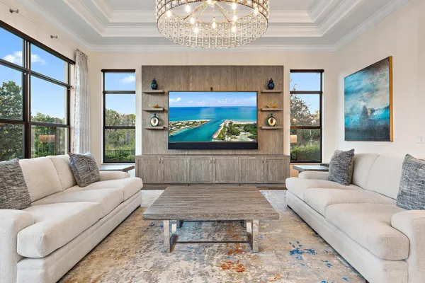 a living room with furniture a chandelier and a large window