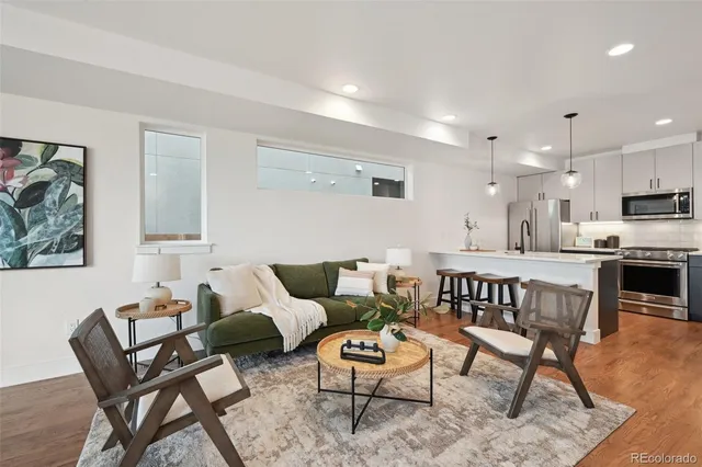 a living room with furniture and a wooden floor