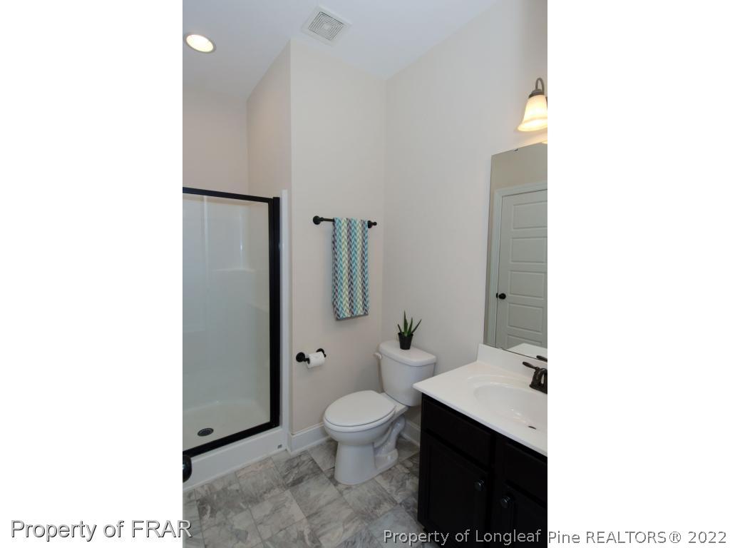 105 Caulfield Road Aberdeen, NC 28315 - Photo 14 of 36 a bathroom with a toilet a sink and mirror
